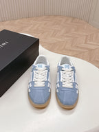 Pair of low-top sneakers in blue with white panels and tan gum rubber soles.