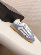 Blue low-top sneaker with white contrast straps and lace-up closure.