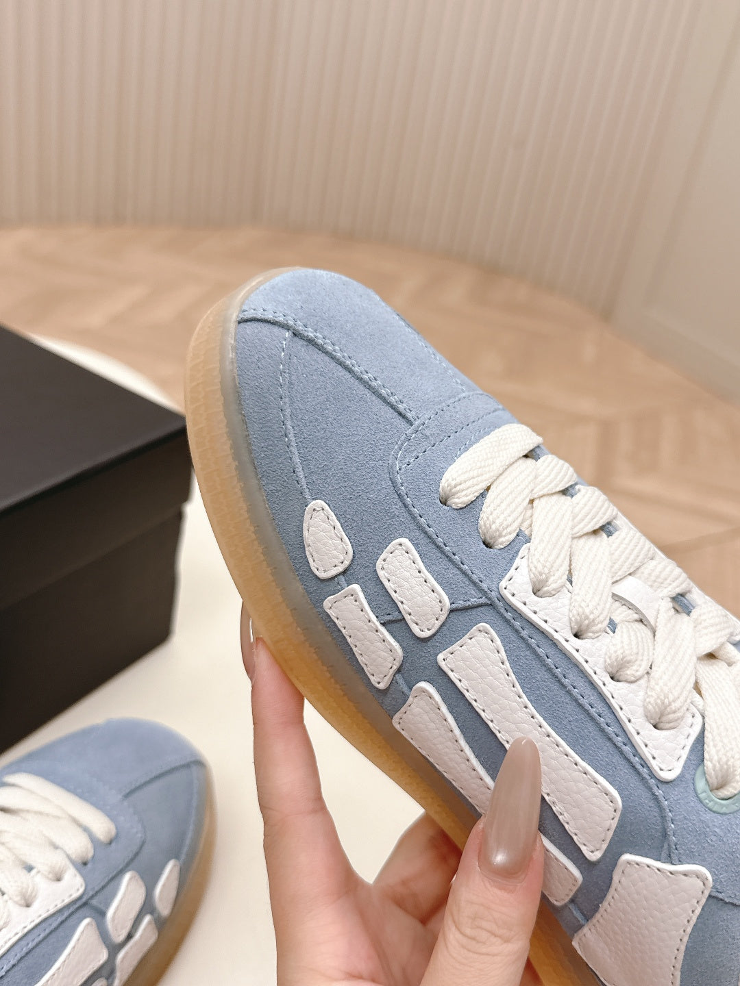Blue low-top sneaker with white overlays and textured sole edge.