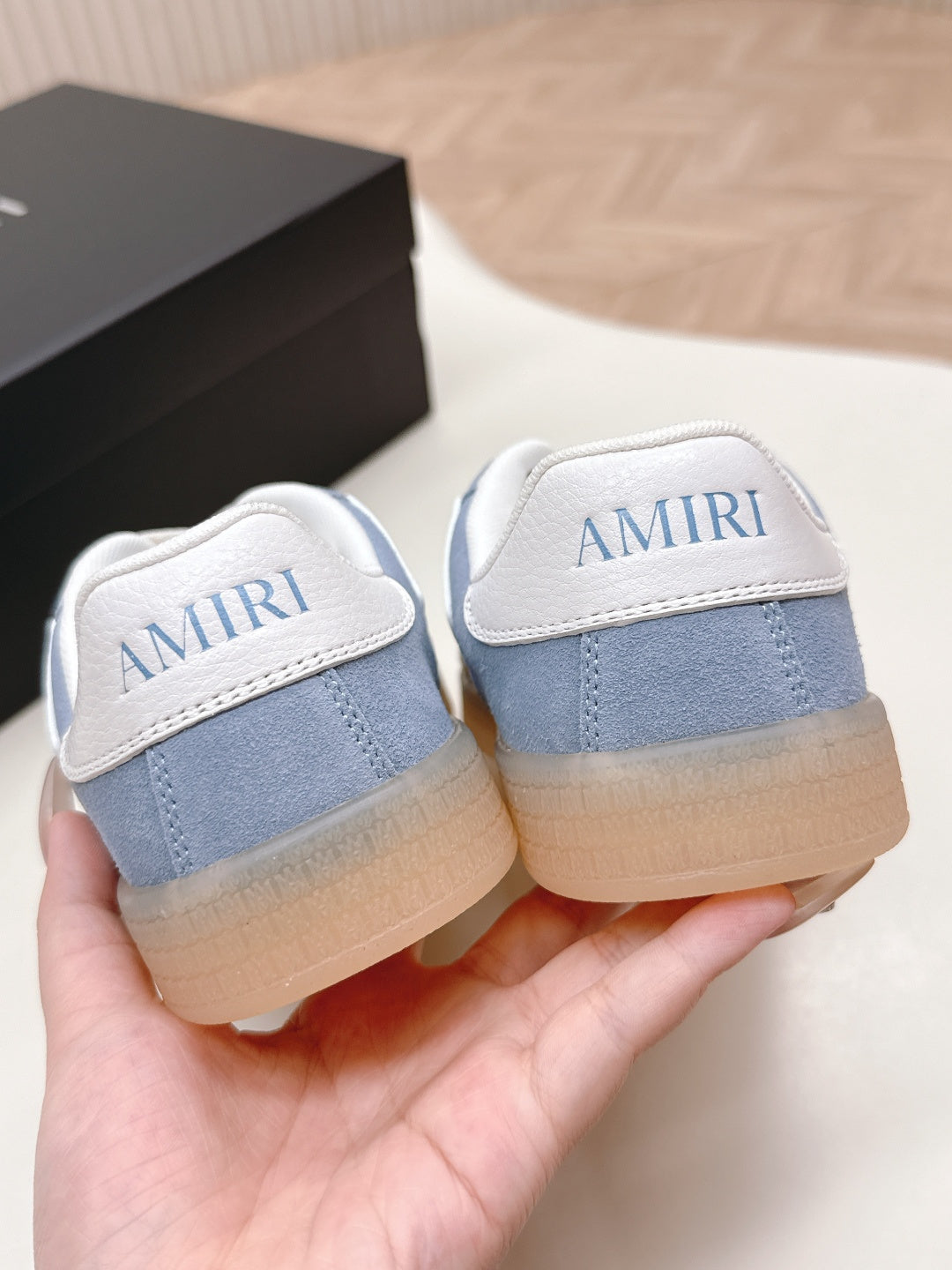 Blue low-top sneakers with white heel tabs and AMIRI-printed backs.