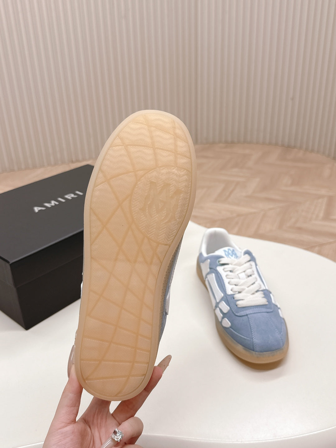 Outsole view of a blue low-top sneaker with tan rubber traction bottom.