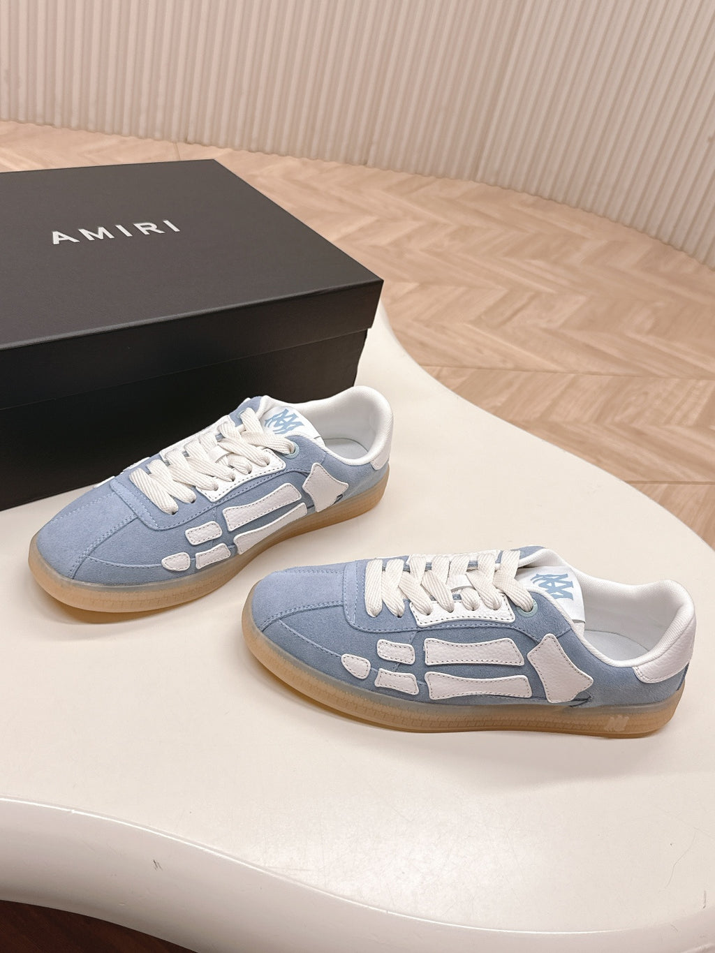 Blue low-top sneakers with white panels and tan gum soles.