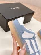 Blue low-top sneaker with white stitch trim and strap-style side design.