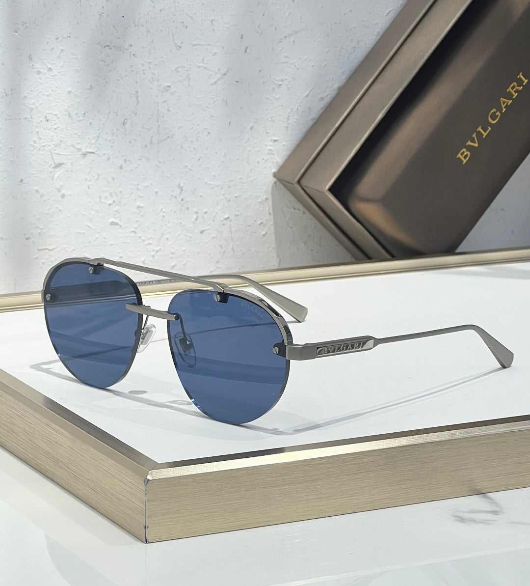 Bvlgari sunglasses with blue-tinted lenses, silver frame, and straight metal arms
