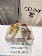 Golden Goose sneakers pair, white uppers with yellow and brown laces on display box