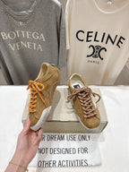 Golden Goose tan sneaker in hand with white star patch and brown laces
