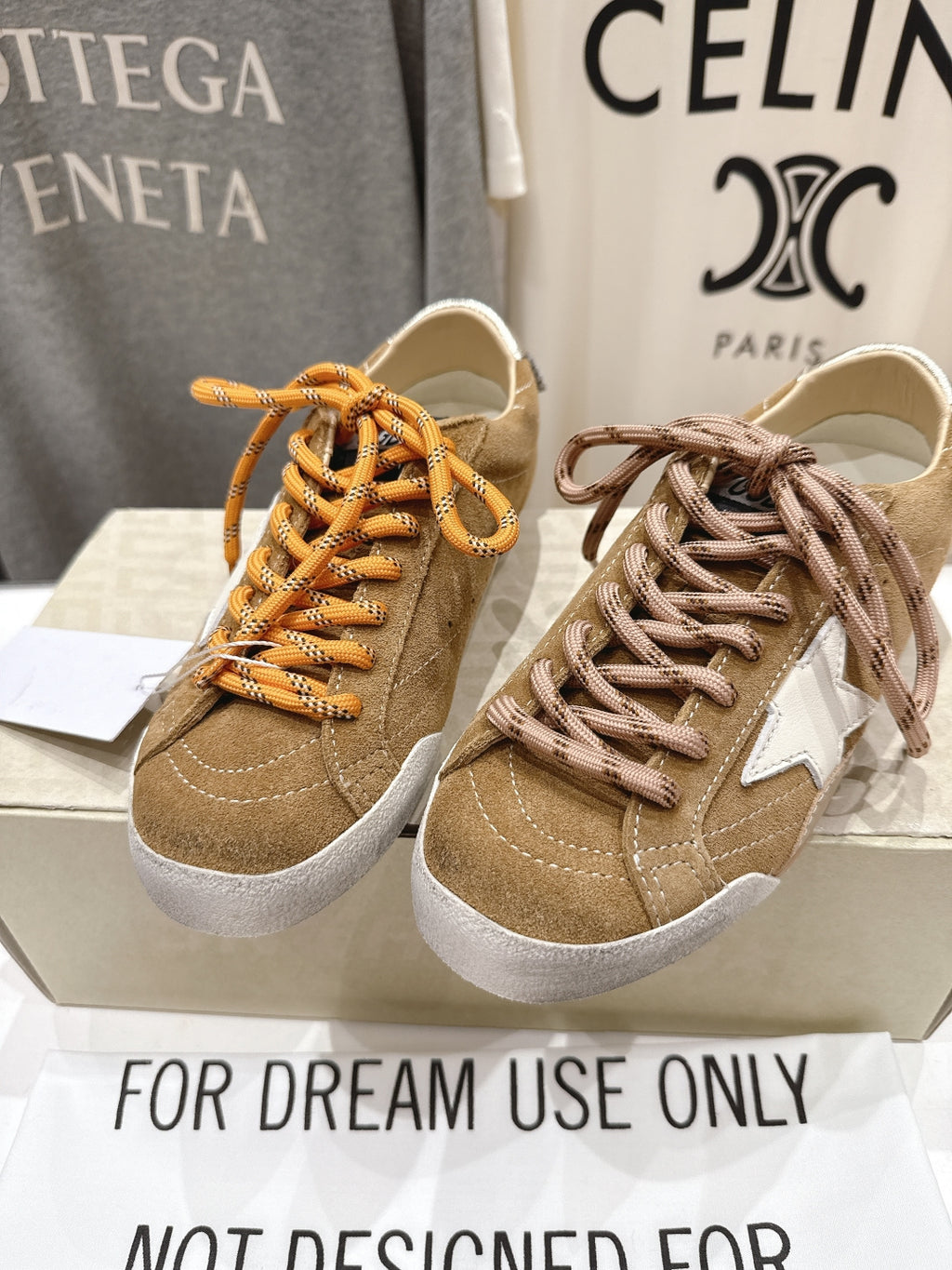 Golden Goose sneakers side-by-side: tan with orange and brown laces, white rubber soles