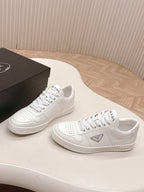 White Prada unisex sneakers with PRADA emblem, angled side view