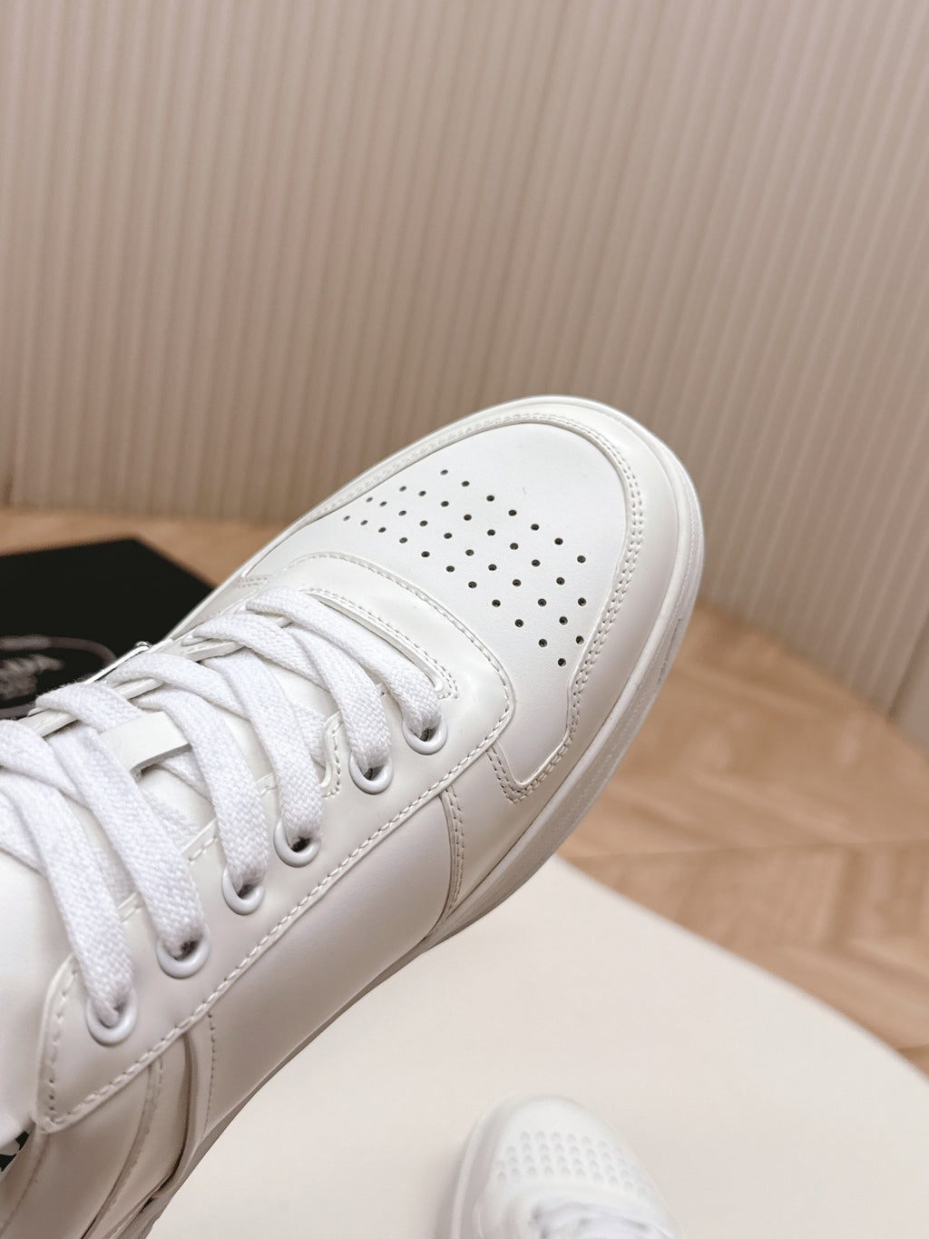 White Prada unisex sneakers, perforated toe and lace-up detail close-up