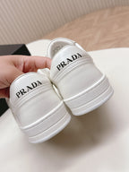 White Prada unisex sneakers heel close-up with PRADA Milano text