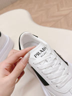 Prada unisex white sneaker with black side panel, logo text on tongue