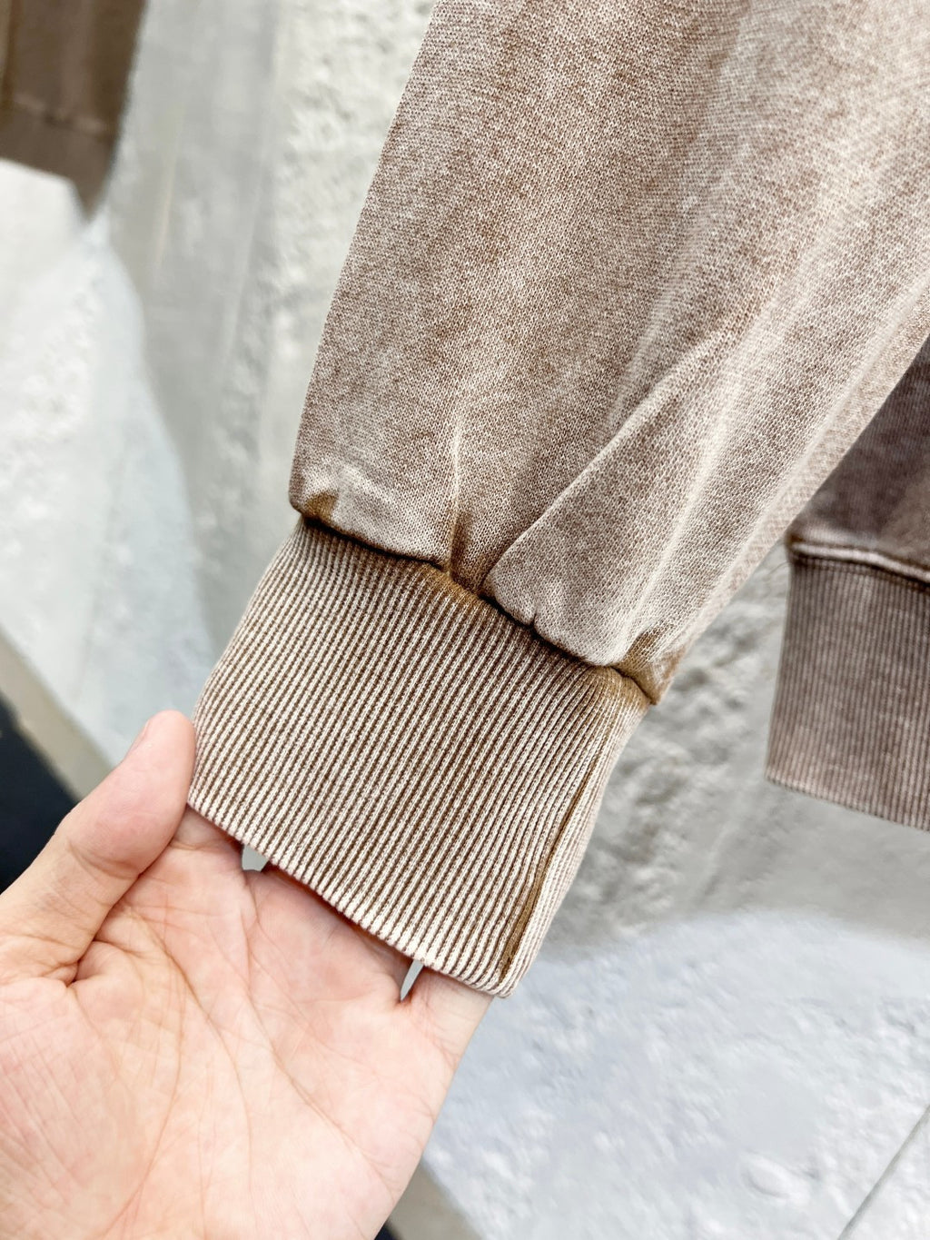 Beige hoodie cuff and hem detail with ribbed knit sleeve end.