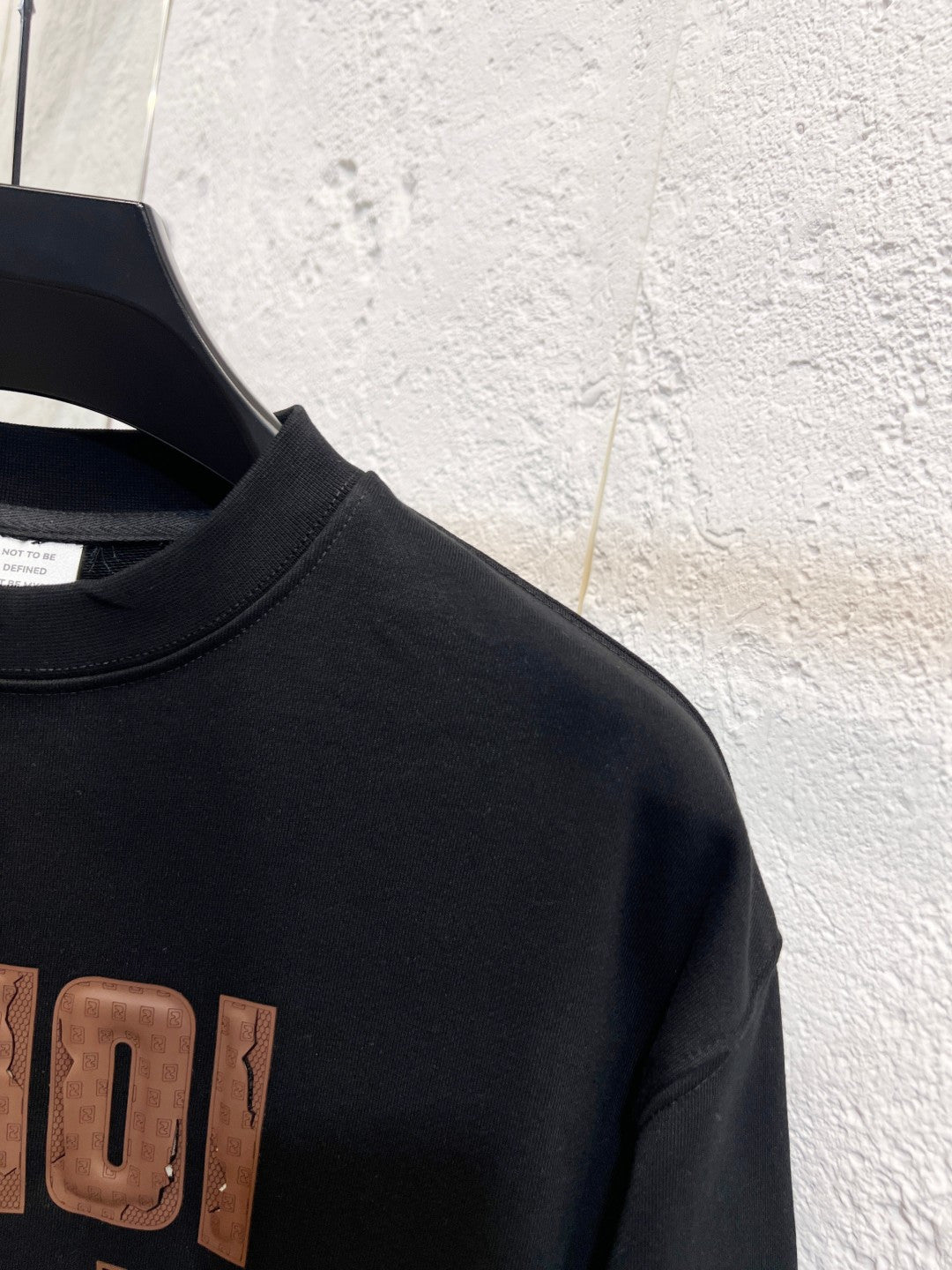 Black sweatshirt neckline and partial FENDI logo on chest