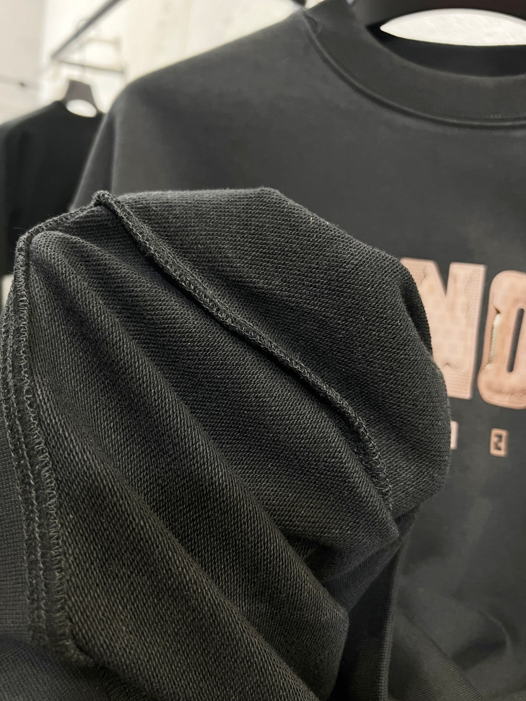 Black sweatshirt shoulder and sleeve with ribbed cuff detail