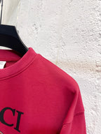Bright pink Gucci sweatshirt shoulder and partial GUCCI lettering