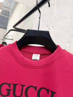 Bright pink Gucci sweatshirt neckline close-up with GUCCI lettering