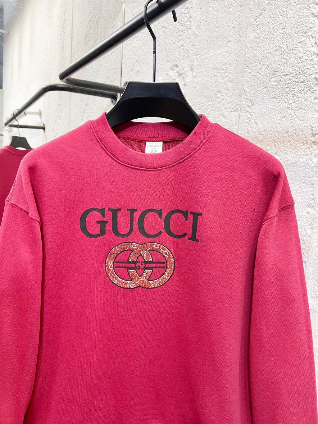 Bright pink Gucci sweatshirt with large front GUCCI text and crest emblem