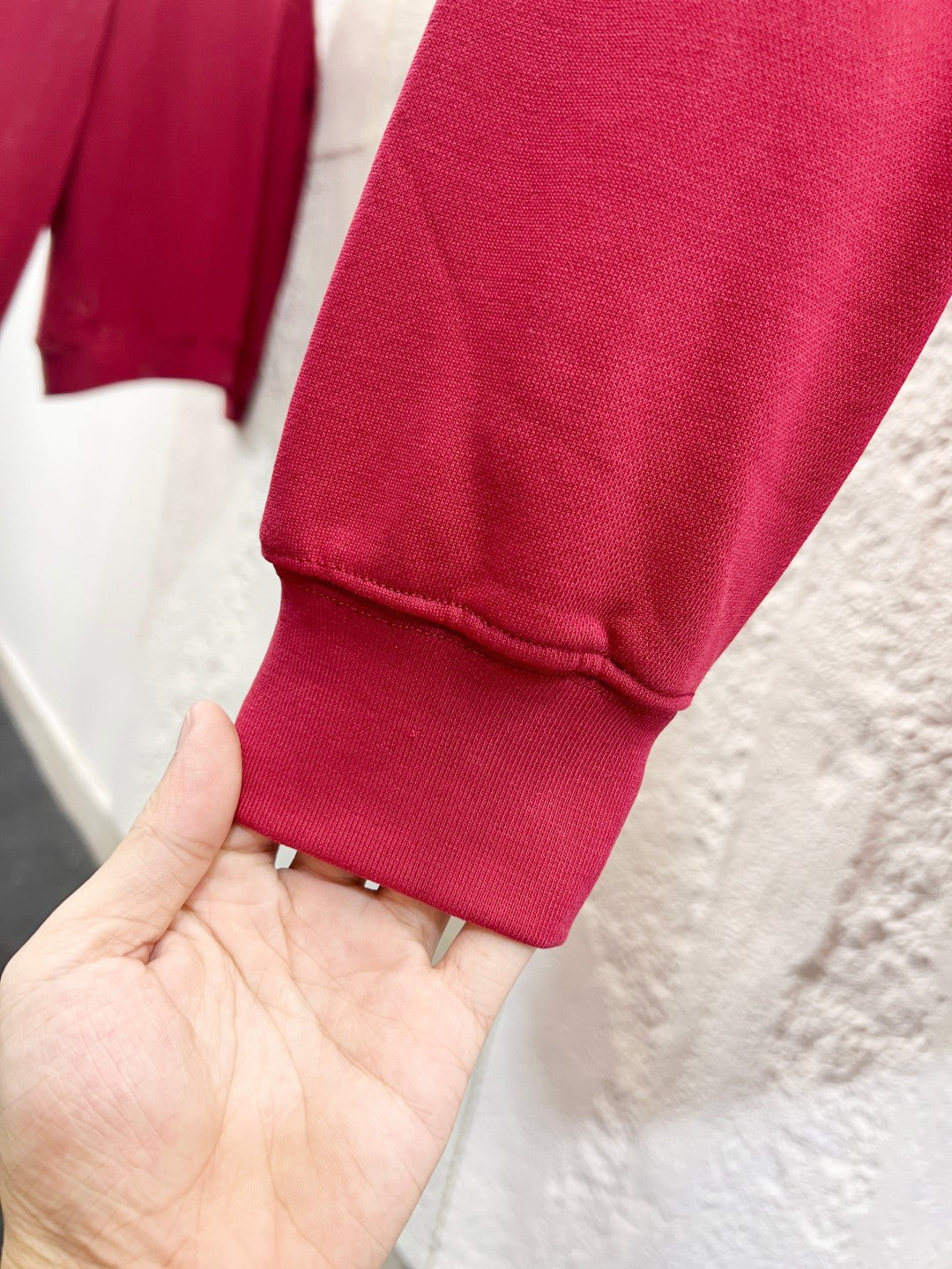 Bright pink sweatshirt cuff with ribbed hem on a hand
