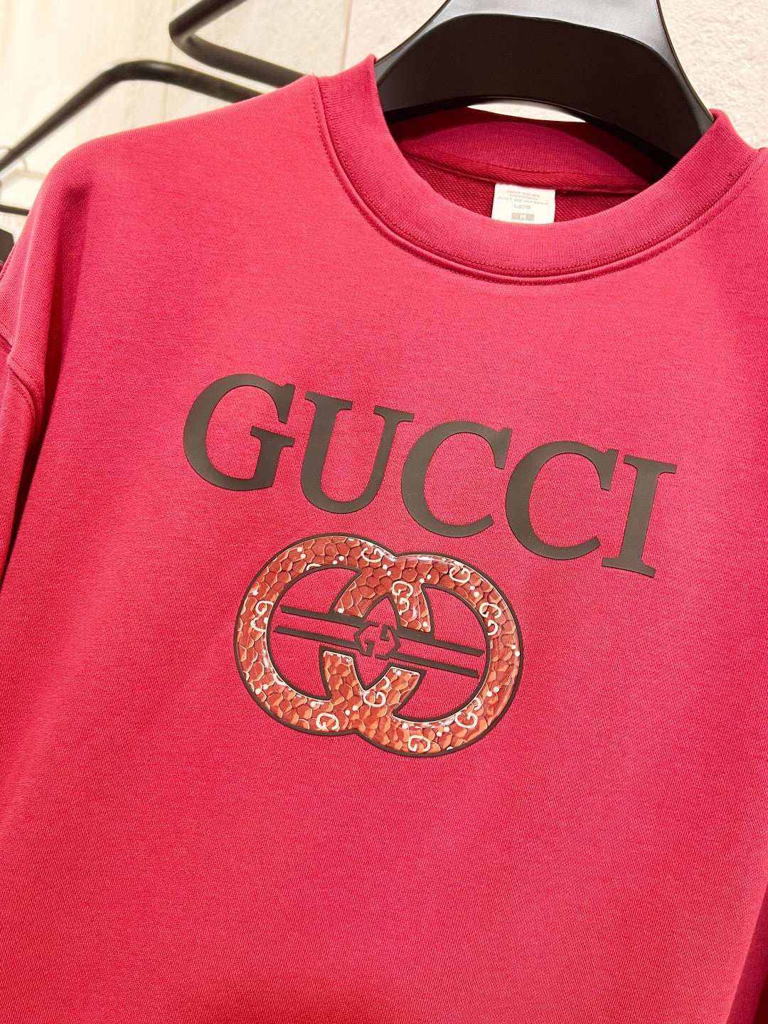 Bright pink Gucci sweatshirt with GUCCI text and circular crest emblem