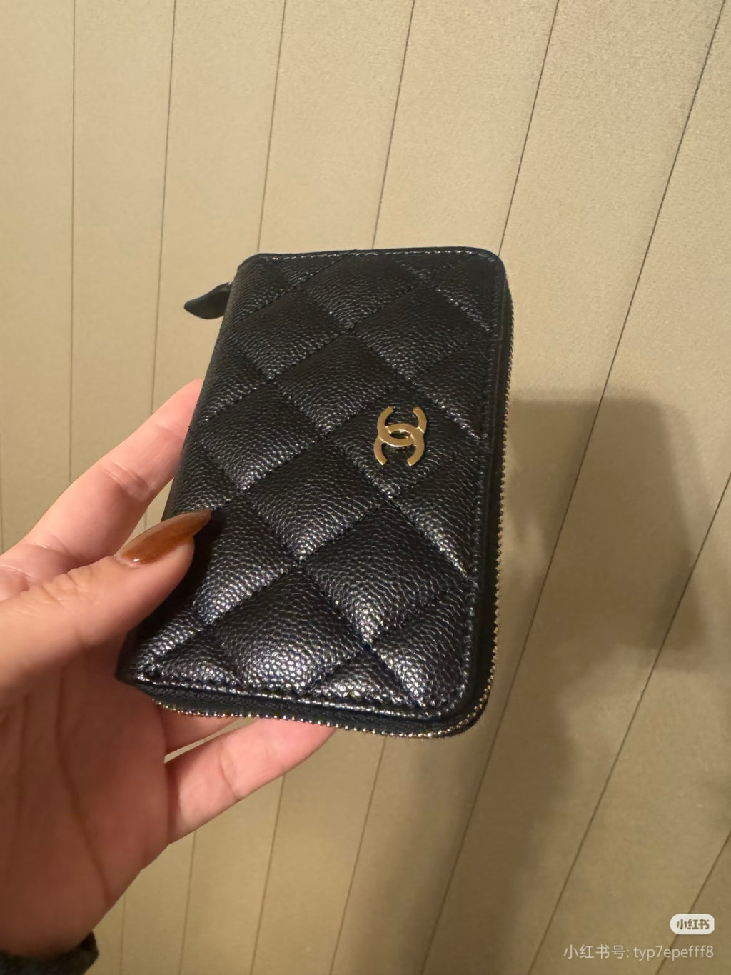 Chanel small zip pouch in dark quilted leather with gold CC emblem and side zipper.