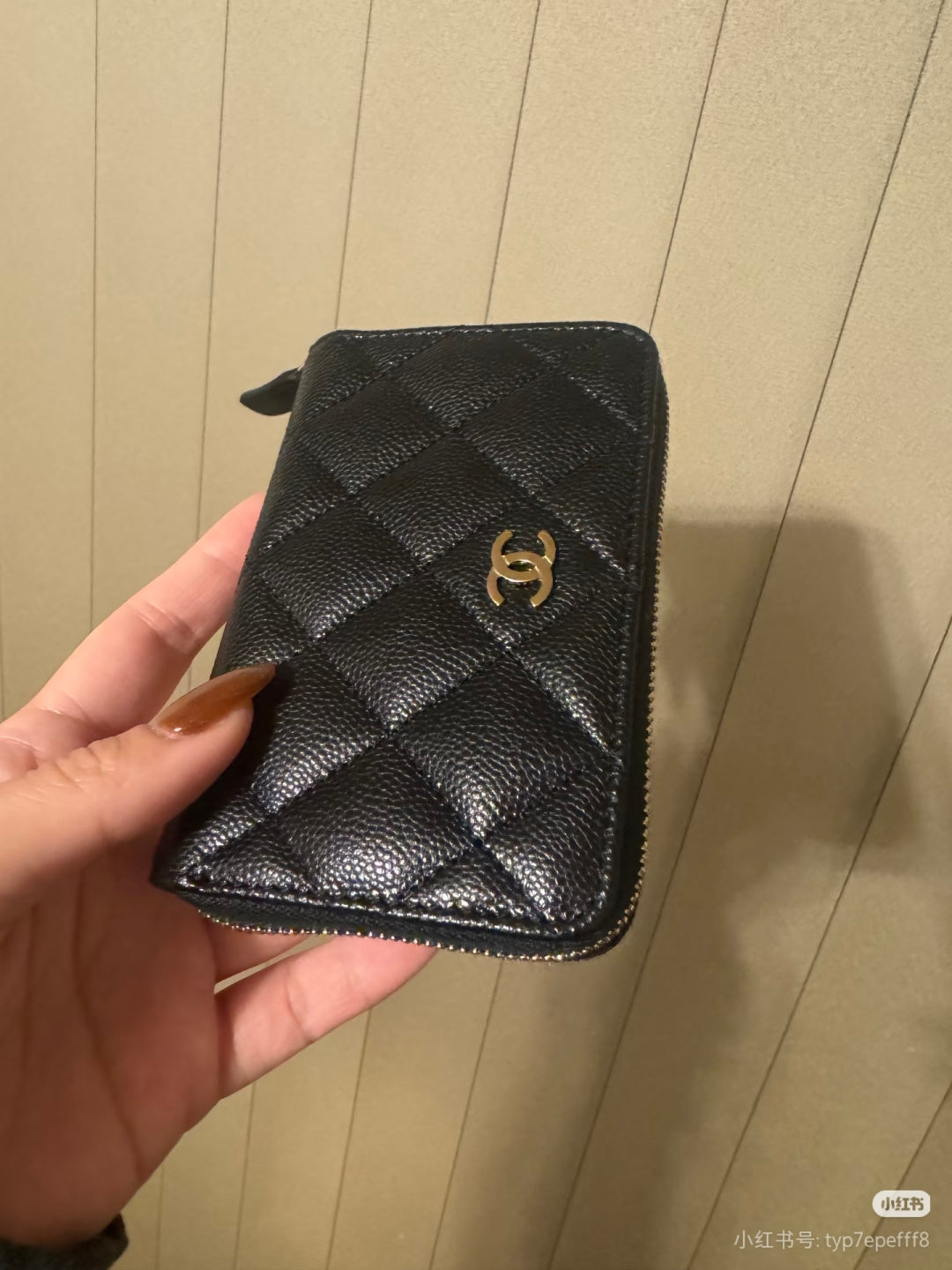Chanel small zip pouch in dark quilted leather with gold CC emblem and side zipper.