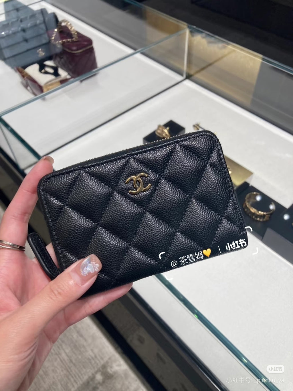 Quilted Chanel small bag with gold CC logo, dark exterior and zip top with gold trim.