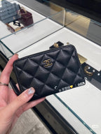 Quilted Chanel small bag with gold CC logo, dark exterior and zip top with gold trim.