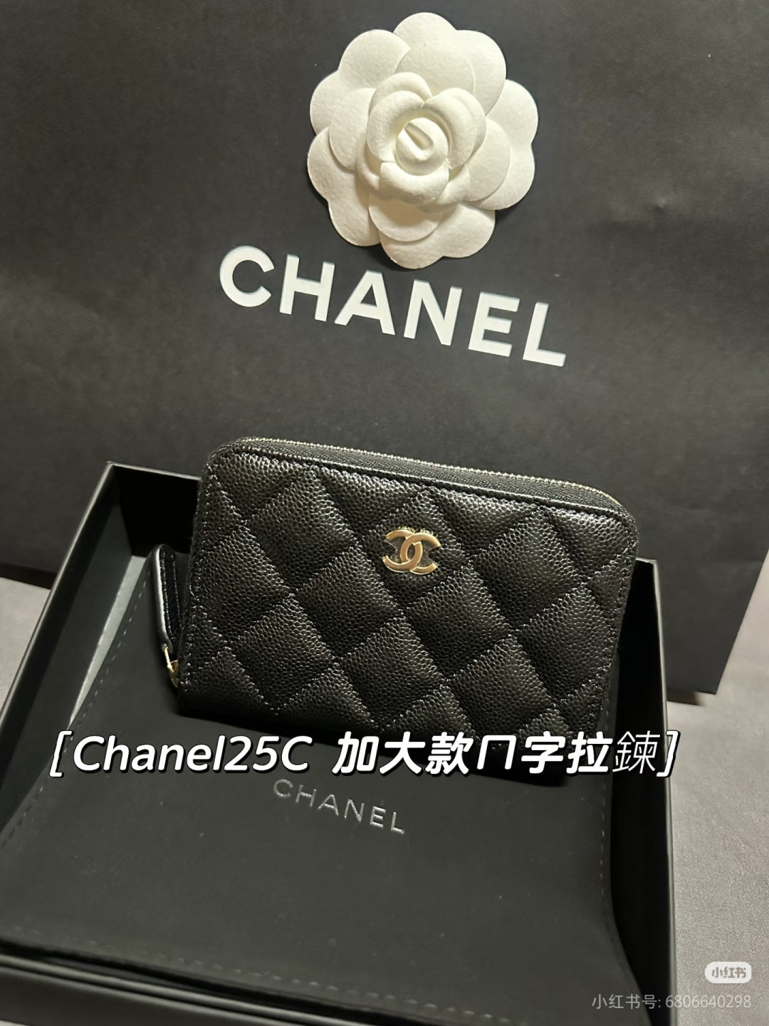 Chanel small zip bag with quilted dark exterior and gold CC logo, front view.