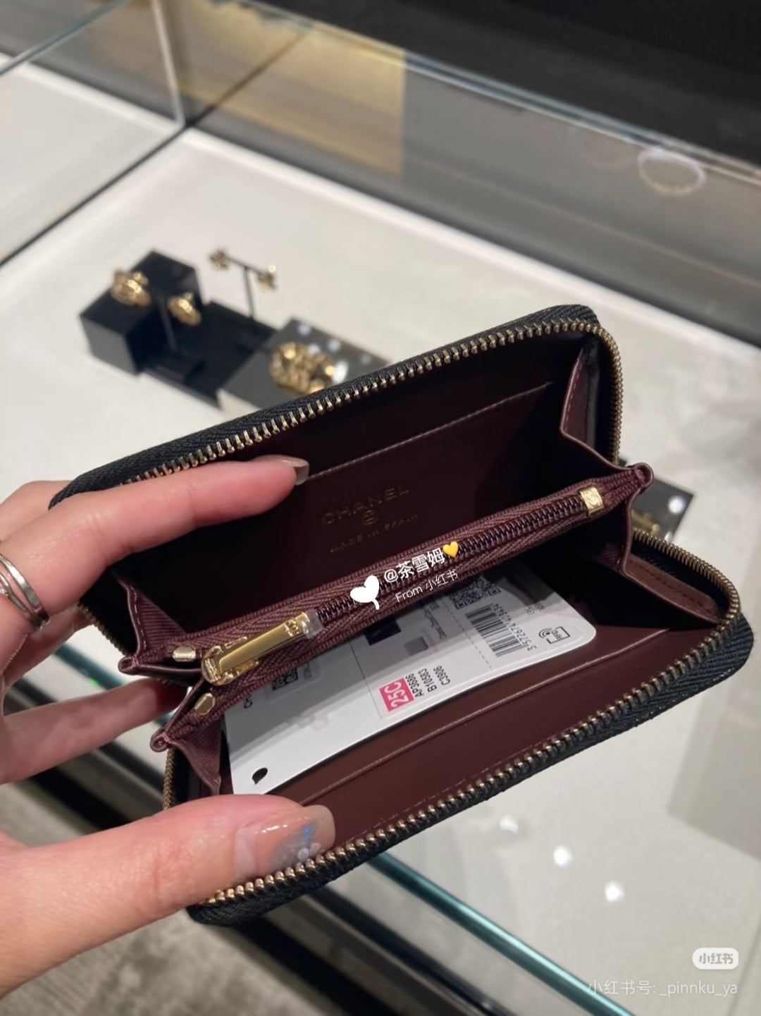 Chanel small bag open with burgundy lining, card slots, and gold zipper hardware.