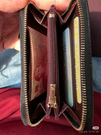 Chanel small bag open with burgundy lining, gold zipper edges, and card slots inside.