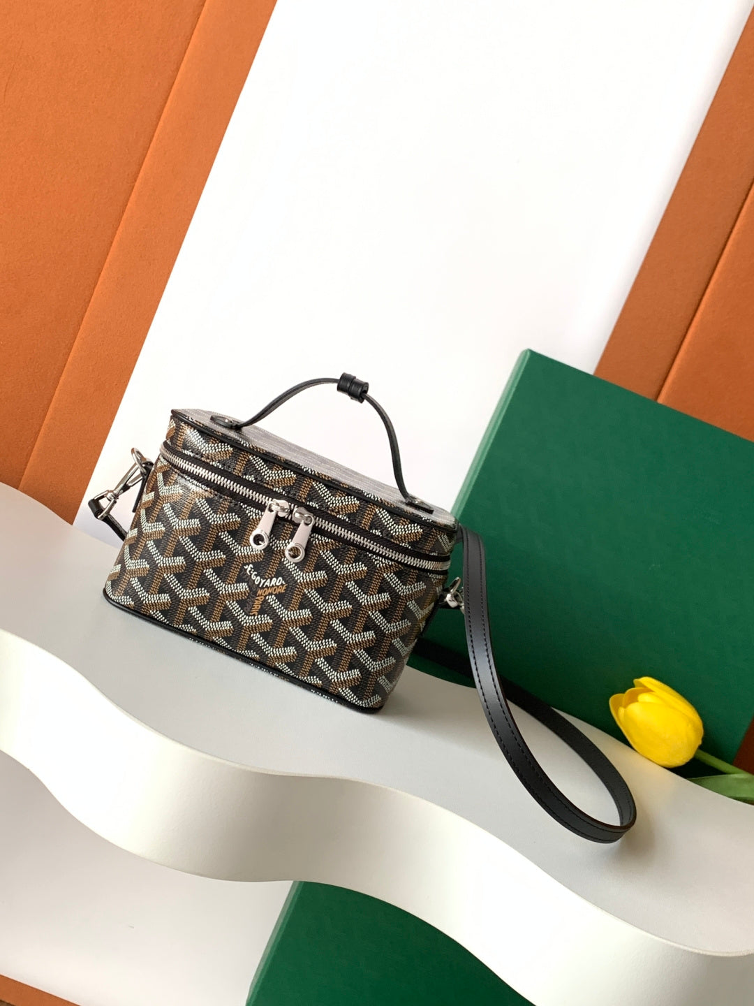 Goyard patterned crossbody bag with black leather strap and top handle