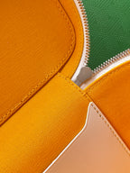 Goyard mini bag closeup of orange textured panel with cream leather trim