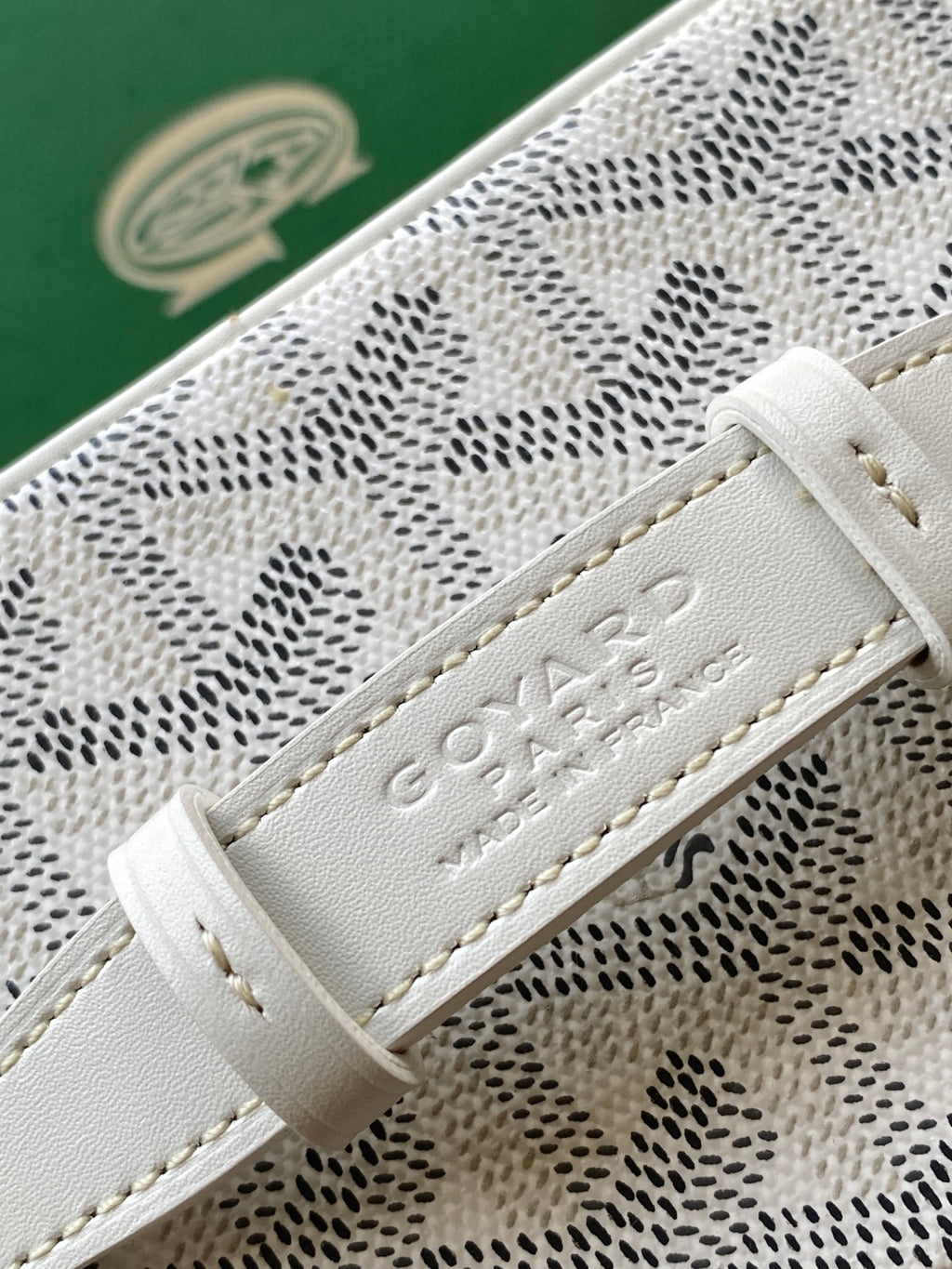 Goyard patterned mini bag closeup of leather strap with embossed logo