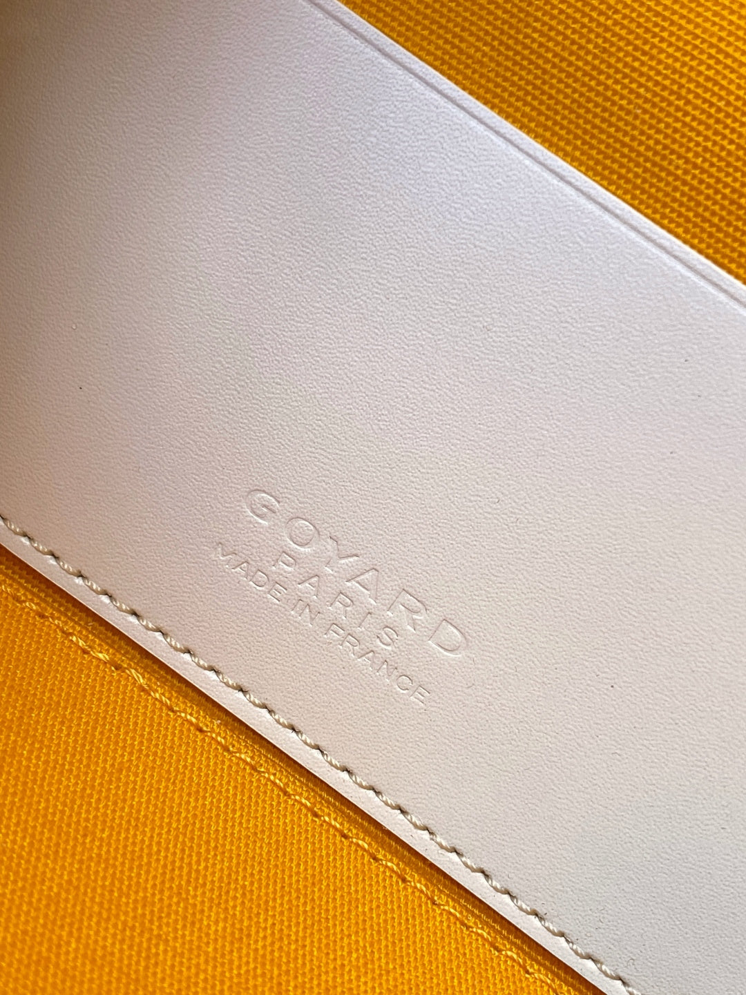 Goyard mini bag closeup of embossed logo on cream leather trim