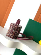 Goyard mini crossbody bag with top handle, burgundy strap, monogram canvas