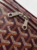 Goyard zipper hardware and logo patch on monogram canvas bag, close-up