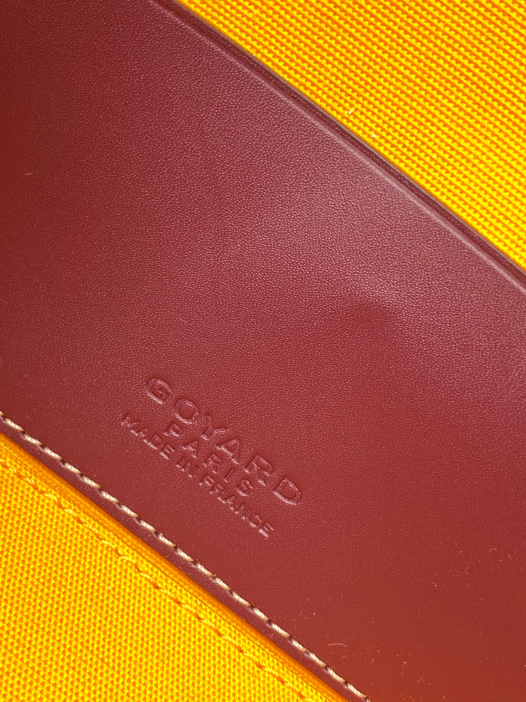 Goyard leather corner close-up with embossed logo and contrast stitching