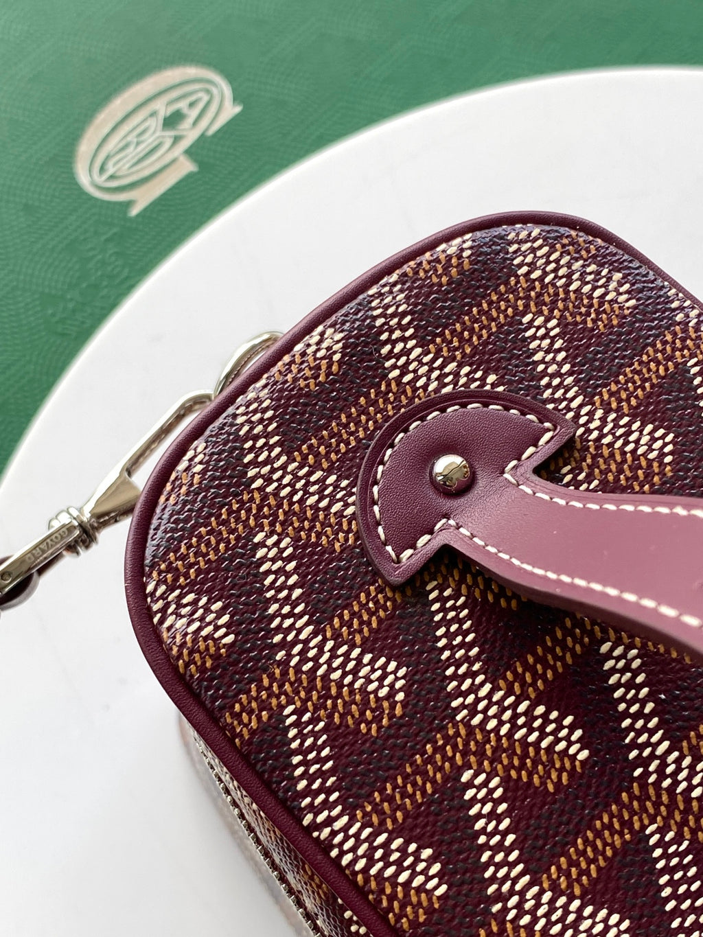 Goyard rounded crossbody bag with burgundy leather strap and monogram canvas
