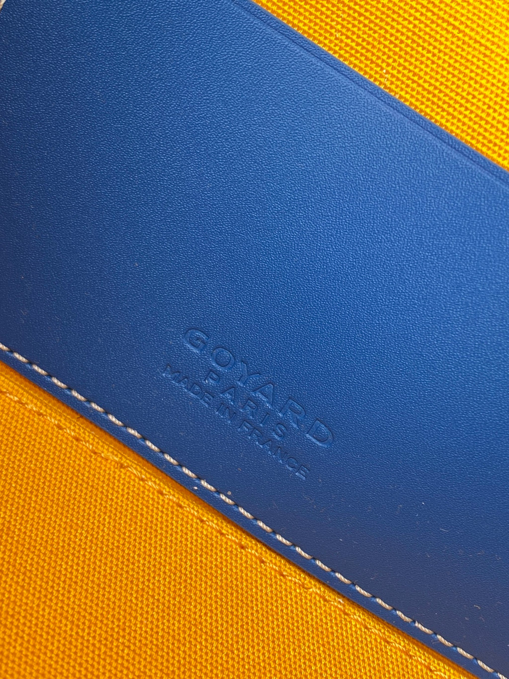 Goyard blue and yellow leather-trim bag corner with stamped logo and stitching