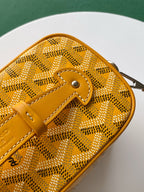 Yellow monogram bag front with leather strap loop and metal clasp hardware