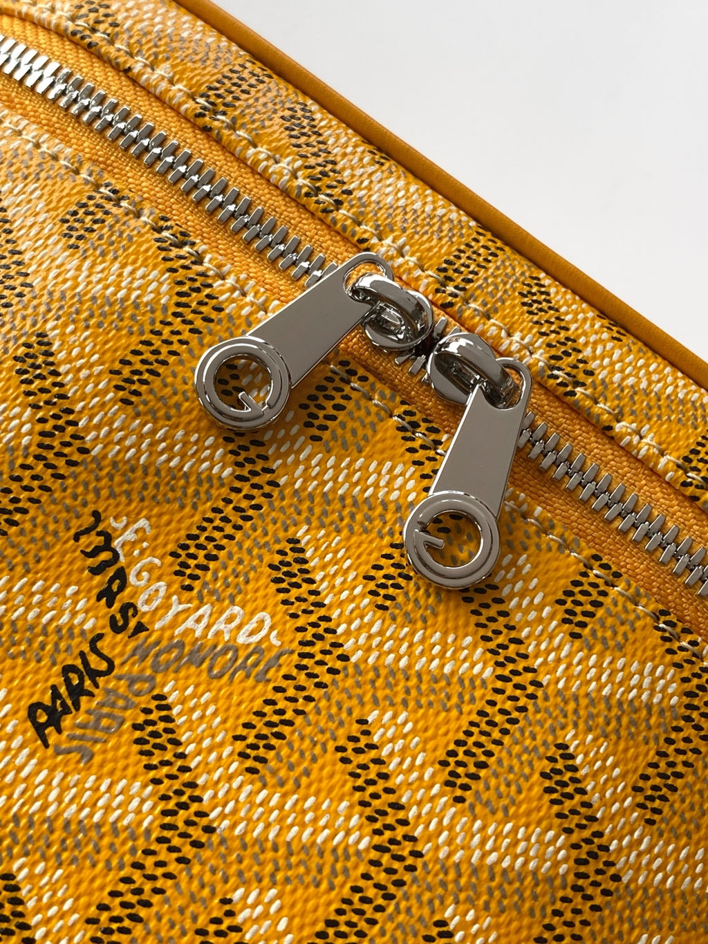 Yellow monogram bag zipper with metal pulls and snap hardware