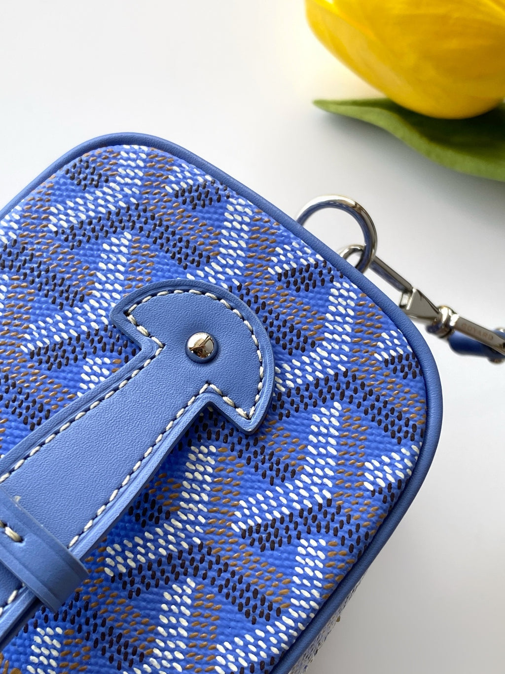 Blue patterned crossbody bag top corner with stitched loop detail