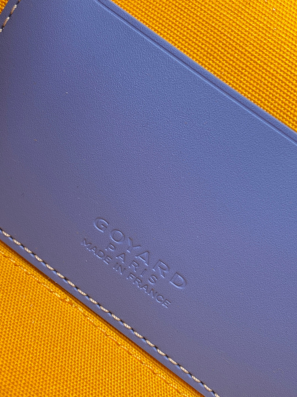 Blue leather patch with embossed mark on crossbody bag