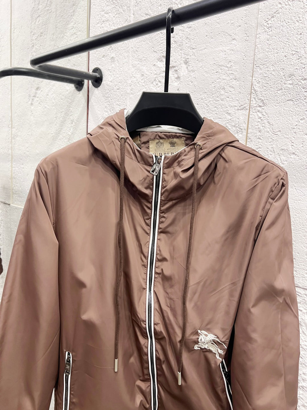 Taupe hooded jacket with front zipper, chest pocket zips, and small horse logo