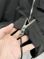 Prada jacket zipper and pull tab detail on black fabric