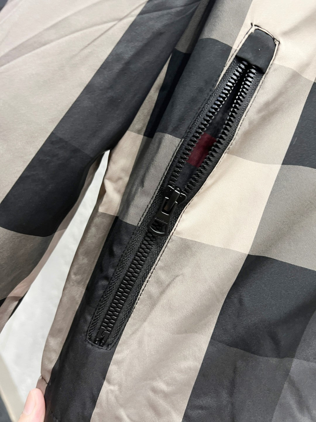 Burberry jacket close-up of front zipper on dark gray and check pattern