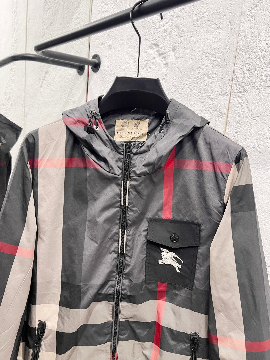 Burberry hooded jacket front with check pattern, zipper, and horse logo pocket patch