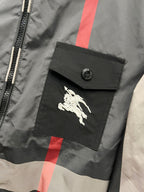 Burberry horse logo patch on pocket of check hooded jacket, dark gray with red stripe