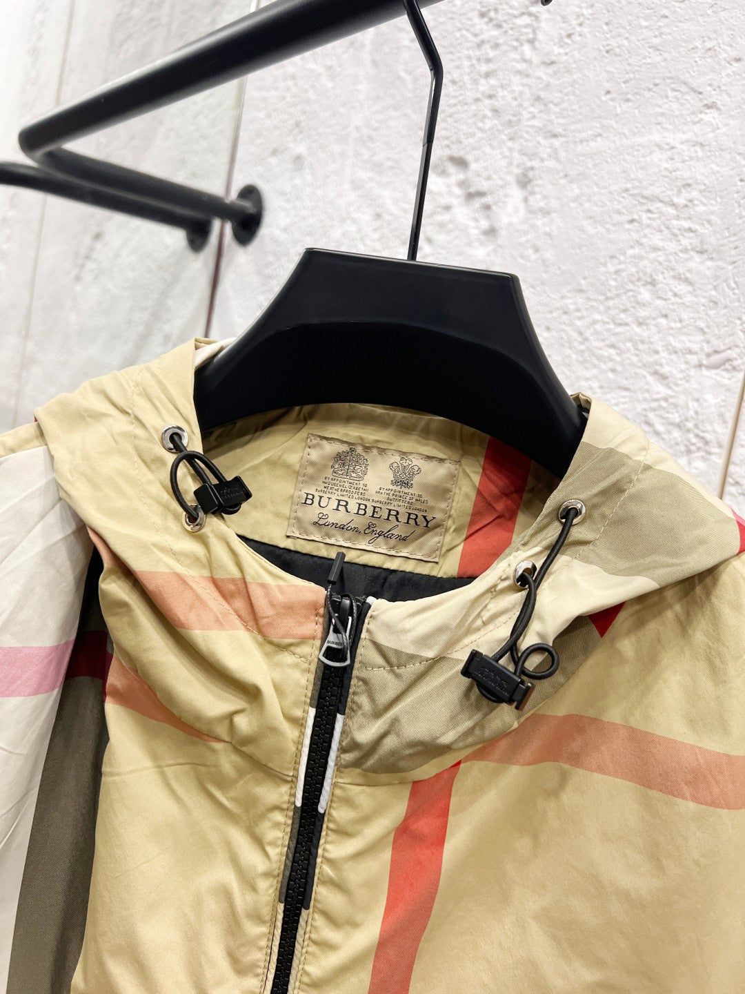 Burberry check hooded jacket on hanger, front view with drawstring tabs