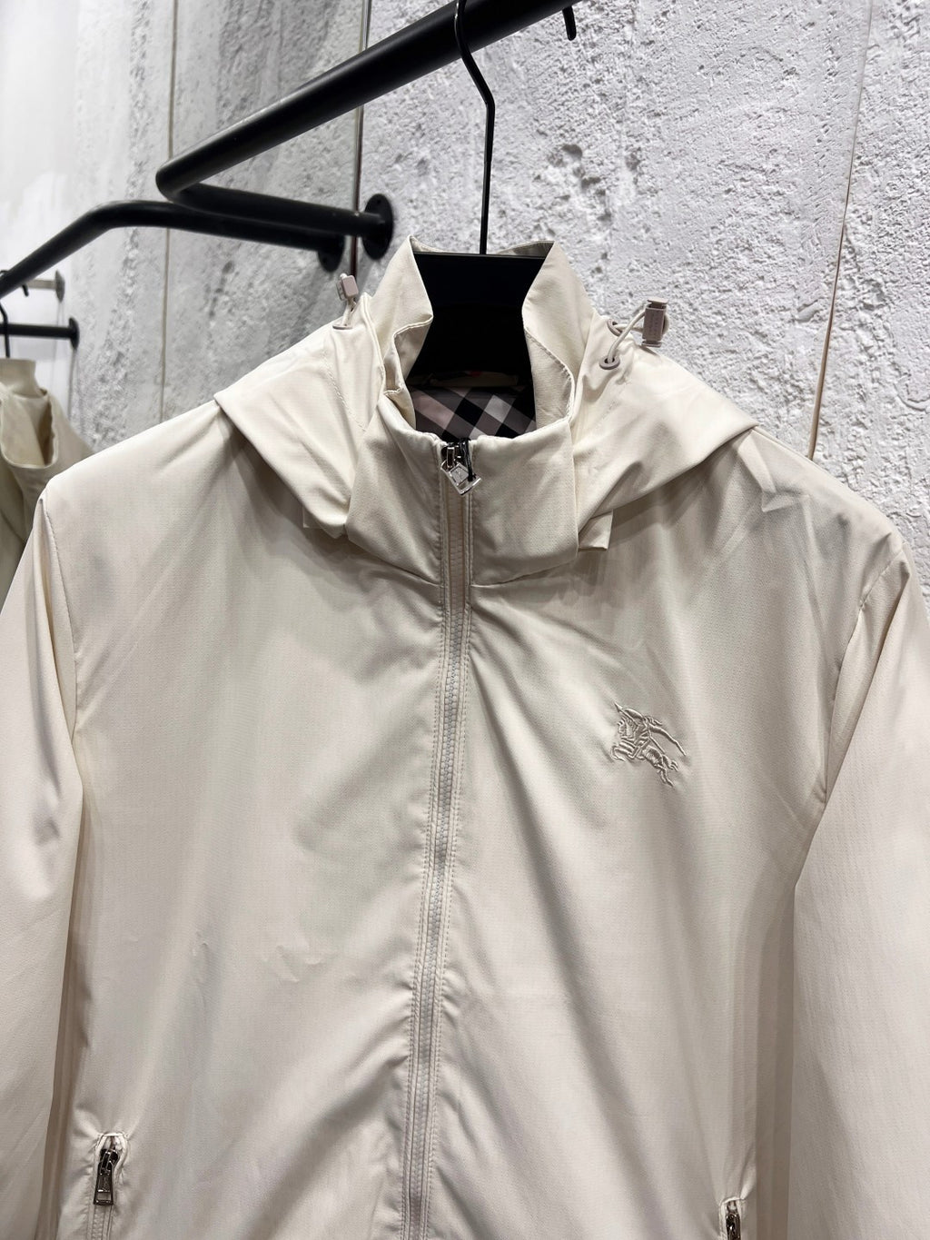 White hooded jacket front with stand collar, full zipper, and small chest logo